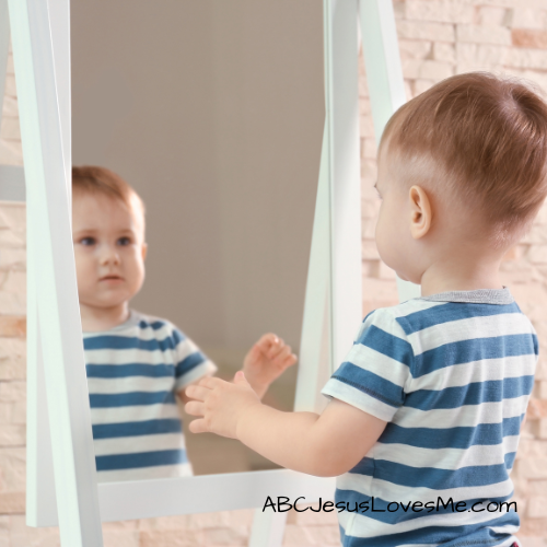 Child looking in the mirror.