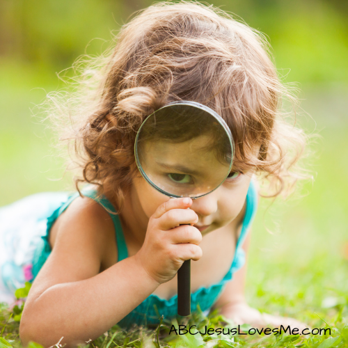 Child looking through a magnifying glass