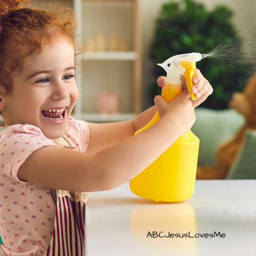 Little girl spraying water from a spray bottle