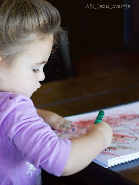 Child coloring with a crayon.