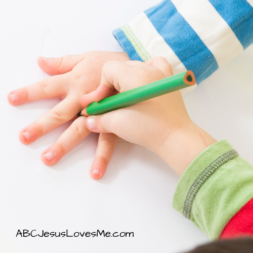 Drawing around a child's hand with a pencil.