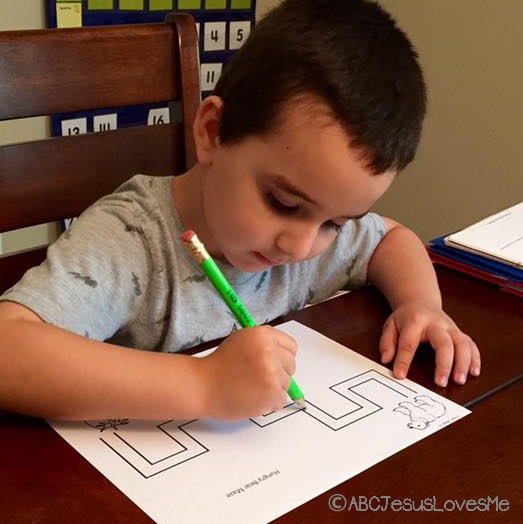 Preschooler doing a maze worksheet.