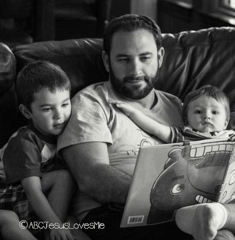 Father reading books with his children.