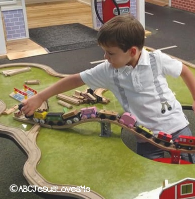 Preschooler playing with wooden trains.