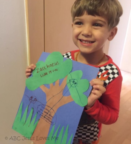 Boy holding his Zacchaeus Craft.